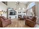 Spacious living room with a vaulted ceiling, large windows, fireplace, and comfortable leather seating at 286 Claymoor Ct, Castle Pines, CO 80108