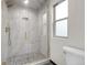 Bright bathroom features a glass enclosed shower with a gray mosaic tile floor and gold hardware at 12671 W Dakota Dr, Lakewood, CO 80228