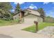 Charming home featuring stone accents, a well-manicured lawn, and a two-car garage at 12671 W Dakota Dr, Lakewood, CO 80228