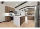 Bright, open kitchen with stainless appliances, light wood cabinets, island, and dark exposed beams at 12671 W Dakota Dr, Lakewood, CO 80228