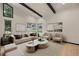 Beautifully staged living room featuring hardwood floors, black ceiling beams, and comfortable modern furnishings at 12671 W Dakota Dr, Lakewood, CO 80228