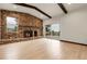 Living room showcases stone fireplace, wooden beam accents, and sliding door access to deck at 12671 W Dakota Dr, Lakewood, CO 80228