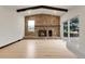 Living room showcases stone fireplace, wooden beam accents, and sliding door access to deck at 12671 W Dakota Dr, Lakewood, CO 80228