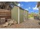 Green storage shed with a white door offering convenient backyard storage next to a fenced yard at 12671 W Dakota Dr, Lakewood, CO 80228