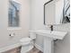 Clean half-bath with pedestal sink and modern black fixtures at 5165 Vivian St, Wheat Ridge, CO 80033