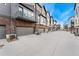 Modern townhomes with private garages, brick accents, and individual AC units line a concrete driveway at 5165 Vivian St, Wheat Ridge, CO 80033