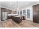 A bright kitchen with a large island, stainless steel refrigerator, and wooden floors at 5165 Vivian St, Wheat Ridge, CO 80033