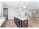 Kitchen island features stainless appliances, stone countertops, and modern lighting at 5165 Vivian St, Wheat Ridge, CO 80033