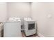 Bright laundry room features a modern washer and dryer set on a wood-look floor at 5165 Vivian St, Wheat Ridge, CO 80033