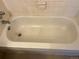 Standard bathtub with tiled surround, faucet hardware, and visible drain for basic bathroom functionality at 8657 Clay St # 383, Westminster, CO 80031