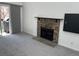 Living room featuring neutral gray carpet, sliding glass doors to a balcony, and a stone fireplace at 8657 Clay St # 383, Westminster, CO 80031