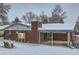 Brick house exterior with a covered patio and snowy backyard at 7025 Newland St, Arvada, CO 80003