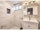 A modern bathroom showcasing marble-style tiled walls, sleek fixtures, and ample lighting at 8097 E Lehigh Dr, Denver, CO 80237