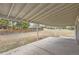 Covered patio overlooking large backyard with mature trees, play structure, and shed at 8097 E Lehigh Dr, Denver, CO 80237