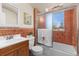 Updated bathroom with tiled shower/tub, mirrored cabinet, and cherry vanity at 700 Holly St, Denver, CO 80220