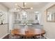 View of kitchen with eat in kitchen, stainless appliances, white cabinets and modern lighting at 700 Holly St, Denver, CO 80220