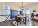 Stylish dining room featuring a modern light fixture, dark accent wall, and seamless access to the patio at 45871 Orchid Ave, Bennett, CO 80102