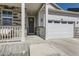Inviting front porch with stone accents, leading to a home with an attached two-car garage and outdoor lighting at 45871 Orchid Ave, Bennett, CO 80102