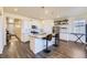 Modern kitchen boasts white cabinets, an island with seating, granite countertops, and stainless steel appliances at 45871 Orchid Ave, Bennett, CO 80102