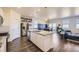 Bright open kitchen featuring a large island with granite countertops, stainless steel appliances, and wood floors at 45871 Orchid Ave, Bennett, CO 80102