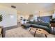 Bright, open-concept living space with a sectional sofa and views of the kitchen and dining areas at 45871 Orchid Ave, Bennett, CO 80102
