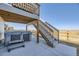Back patio featuring a hot tub and stairway to the deck at 45871 Orchid Ave, Bennett, CO 80102