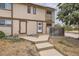 A charming two-story townhome features a neutral exterior, a small porch, and a well-maintained front yard at 8770 Rainbow Ave # B4, Denver, CO 80229