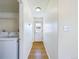 A well-lit hallway with wood floors leads to a laundry room, and has access to the outside at 8770 Rainbow Ave # B4, Denver, CO 80229