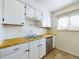 A well-lit kitchen features white cabinets, wood countertops, and modern appliances at 8770 Rainbow Ave # B4, Denver, CO 80229