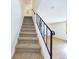 Carpeted staircase with wrought iron railing leads to the upper level, blending style and functionality at 8770 Rainbow Ave # B4, Denver, CO 80229