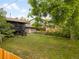 Expansive backyard with a deck, stairs, lush lawn, privacy fence and mature trees at 1029 N Columbine St, Golden, CO 80403