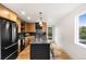 Well-lit kitchen with a black island, stainless steel appliances, and modern wooden cabinetry at 1029 N Columbine St, Golden, CO 80403