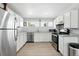 The kitchen features white cabinets, modern appliances, and wood-style flooring at 9175 Cole Dr, Arvada, CO 80004