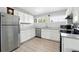 The kitchen features white cabinets, modern appliances, and wood-style flooring at 9175 Cole Dr, Arvada, CO 80004