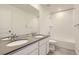 Bright bathroom with dual sinks, white cabinets, gray countertops, and a shower-over-tub combination at 16686 E 110Th Ave, Commerce City, CO 80022