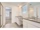 Modern bathroom featuring double sinks, sleek countertops, and a glass-enclosed shower at 16686 E 110Th Ave, Commerce City, CO 80022