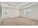 Large bedroom with neutral carpet, tray ceiling, and windows offering natural light at 16686 E 110Th Ave, Commerce City, CO 80022