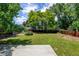 Large backyard featuring a spacious deck, lush lawn, mature trees, and a wooden privacy fence at 6775 Coors Ct, Arvada, CO 80004