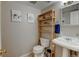 Cozy bathroom with a pedestal sink, open shelving and decorative artwork displayed at 6775 Coors Ct, Arvada, CO 80004