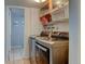 Bright laundry room with modern appliances, storage shelves, and access to another room at 6775 Coors Ct, Arvada, CO 80004