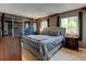 Comfortable main bedroom with large window, mirrored closet, and a gray upholstered headboard at 6775 Coors Ct, Arvada, CO 80004