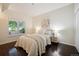 Cozy bedroom features a queen bed, large window, and wood-style flooring at 2895 W Riverwalk Cir # 104, Littleton, CO 80123