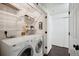 Bright laundry room features a full-size washer and dryer and ample shelving at 2895 W Riverwalk Cir # 104, Littleton, CO 80123