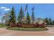 Riverwalk Community sign with brick facade and flags flying in the background at 2895 W Riverwalk Cir # 104, Littleton, CO 80123