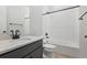 Bathroom featuring a vanity with a light countertop, white tile shower/tub combo, and matte black fixtures at 13690 Emerald Lake St, Parker, CO 80138