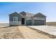 New construction home featuring stone and gray siding, a spacious driveway and a two-car garage at 13690 Emerald Lake St, Parker, CO 80138