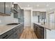 Open kitchen with gray cabinetry, stainless steel appliances, large island, and light backsplash tiles at 13690 Emerald Lake St, Parker, CO 80138