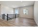 Upstairs living room with two windows, black railings, and light flooring at 13690 Emerald Lake St, Parker, CO 80138