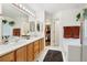 Bright bathroom with a soaking tub, walk-in closet access, and double sink vanity with a plant at 9756 Quay Loop, Broomfield, CO 80021