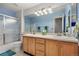 Bright bathroom with double sinks, wood cabinets, large mirror, and a shower-tub combination at 9756 Quay Loop, Broomfield, CO 80021